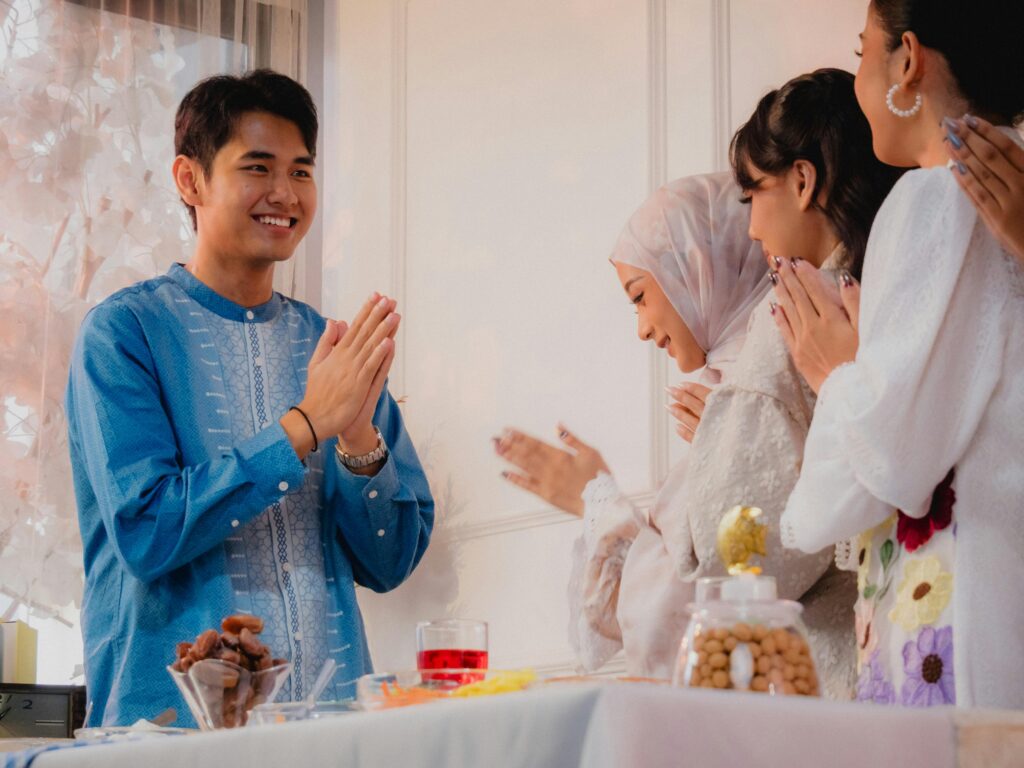 A group of adults celebrating iftar with traditional attire and joyful expressions indoors.